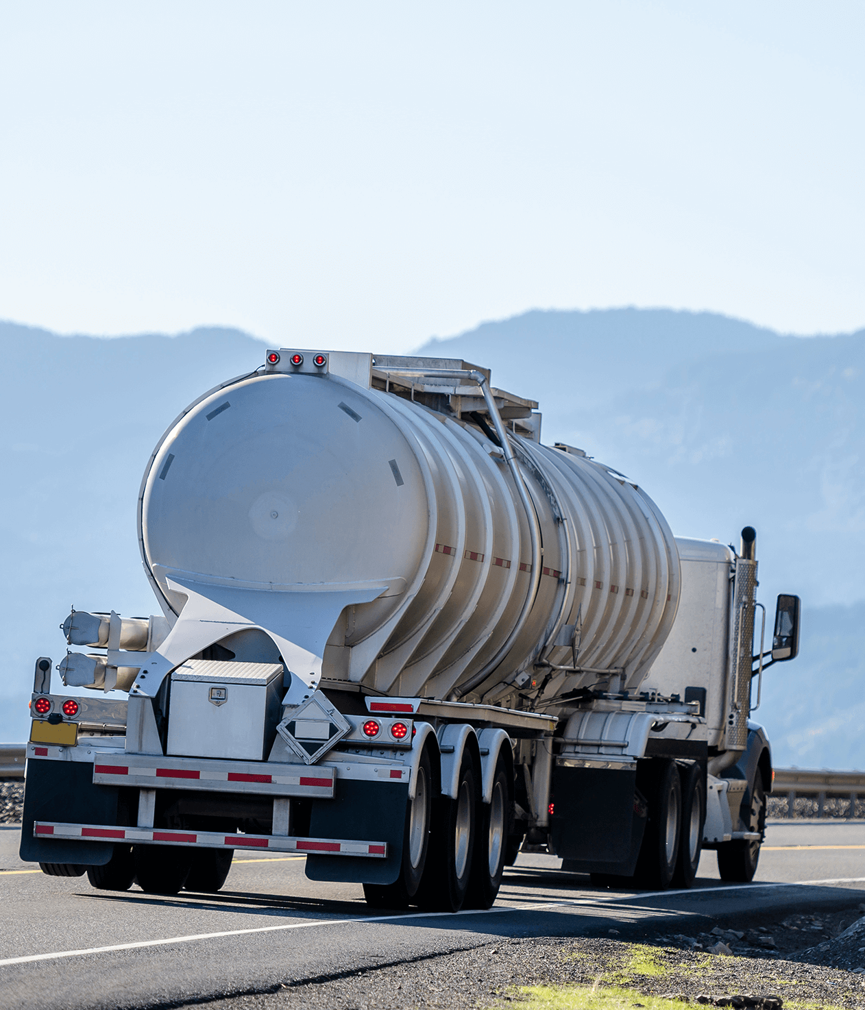 white semi truck with reinforced tank semi trailer for transportation of dangerous liquid chemical